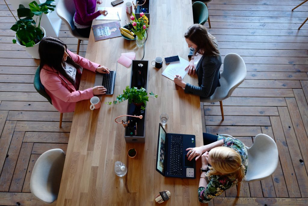 three-woman-sitting-on-white-chair-in-front-of-table-2041627